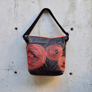 large zippered bag with outer pockets, cross body bag. adjustable strap, two interior pockets,  two exterior pockets, YKK zipper, made in canada, made in toronto, handmade, one of a kind, topstitching, spirals, perfect for travel, perfect everyday, work, gym, play, travel, durable, lightweight, machine washable, chocolate brown with orange stitching