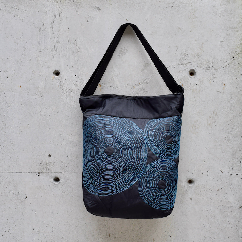 dinner bag, cross body bag. adjustable strap, 2 interior pockets, YKK zipper, made in canada, made in toronto, handmade one of a kind, topstitching, spirals, perfect for travel, perfect everyday, work, gym, play, travel, black with turquoise stitching, durable, lightweight and machine washable,