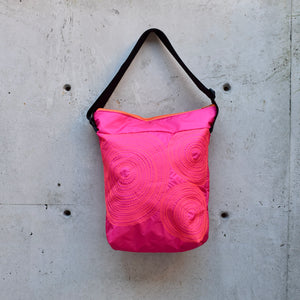 dinner bag, cross body bag. adjustable strap, 2 interior pockets, YKK zipper, made in canada, made in toronto, handmade one of a kind, topstitching, spirals, perfect for travel, perfect everyday, work, gym, play, travel, durable, lightweight and machine washable, hot pink with orange stitching