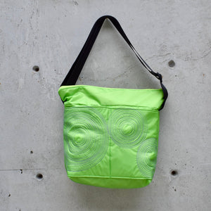 large zippered bag with outer pockets, cross body bag. adjustable strap, two interior pockets,  two exterior pockets, YKK zipper, made in canada, made in toronto, handmade, one of a kind, topstitching, spirals, perfect for travel, perfect everyday, work, gym, play, travel, durable, lightweight, machine washable, lime with mauve stitching